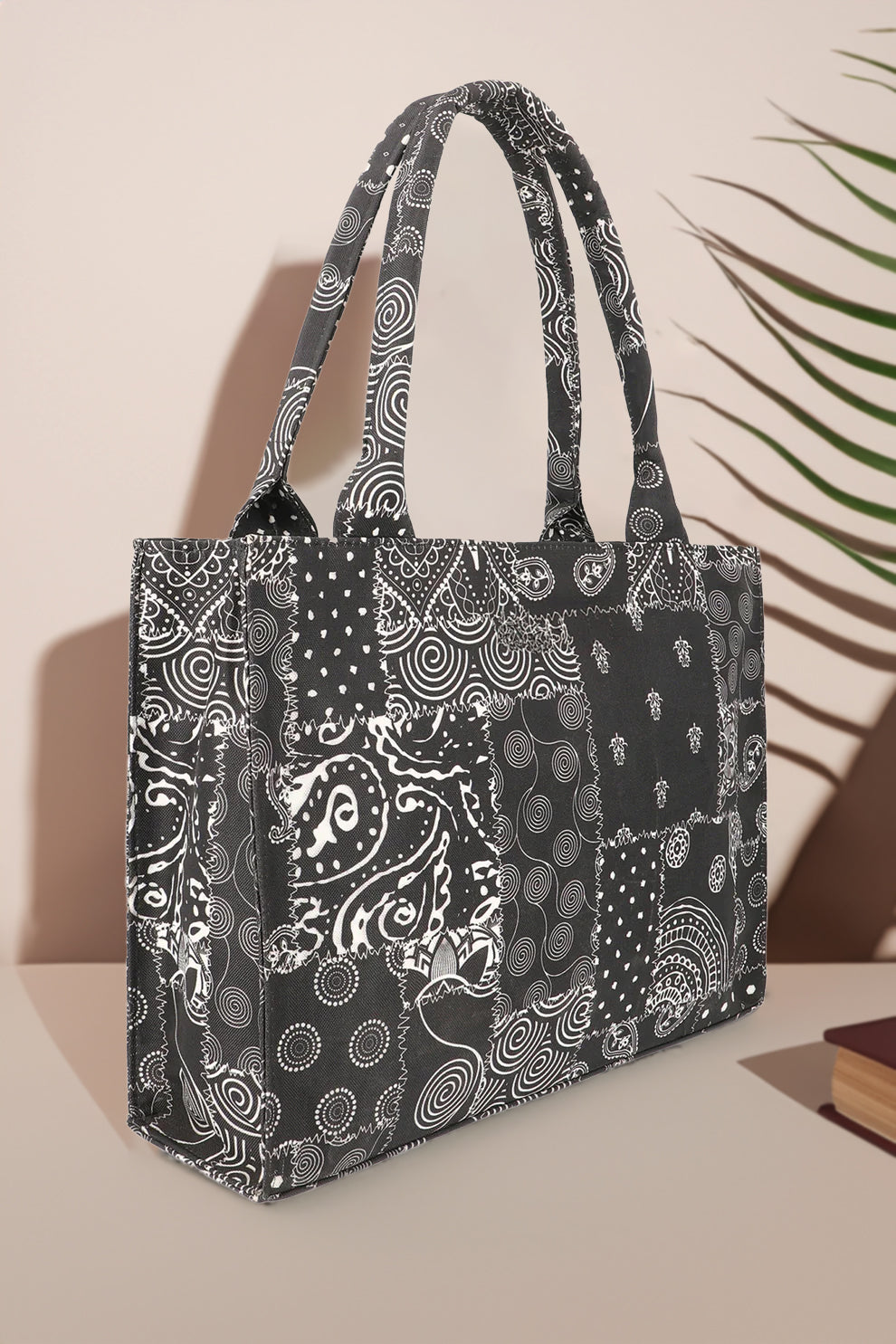 Black patterned tote bag on a beige background